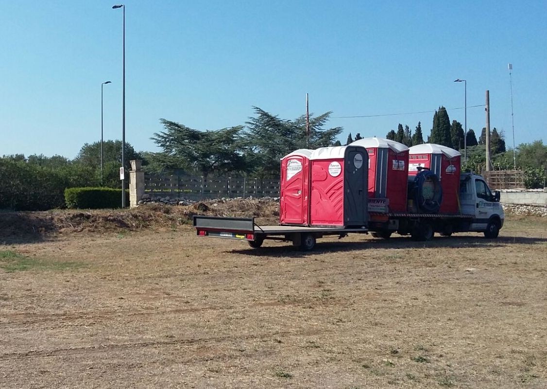 furgone trasporta WC mobili tailorsan su terreno agricolo